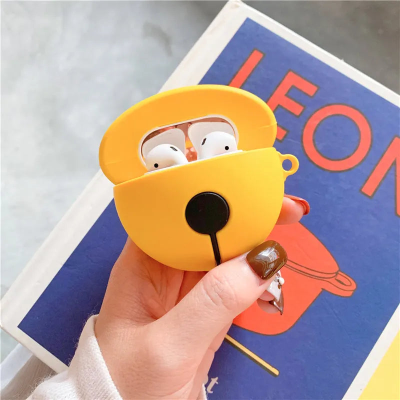 Yellow silicone AirPods case with decorative bell charm for wireless earbuds protection