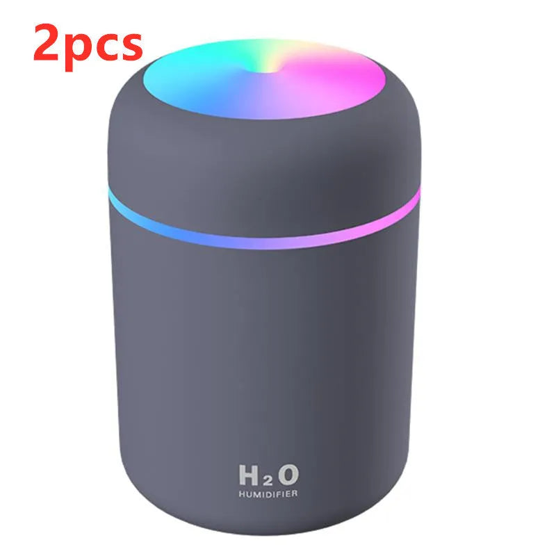 Pink USB desktop humidifier with colourful LED lights and 300ml water tank on wooden desk