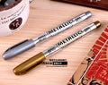 Set of two gold and silver metallic fine tip marker pens with caps on white background
