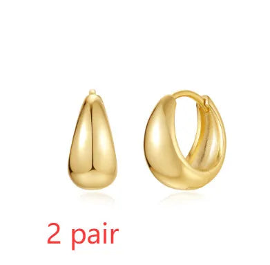 Golden brass earclip earrings with geometric shapes and round elements