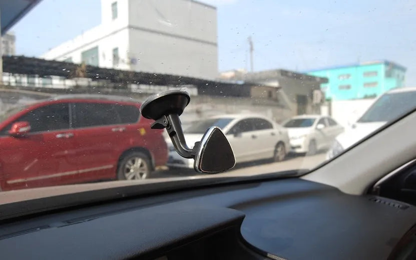 Classic black magnetic car phone holder on dashboard with phone attached, 360-degree rotatable design