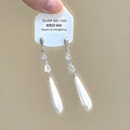 Pair of geometric heart-shaped alloy ear clips with rhinestones and a tassel.