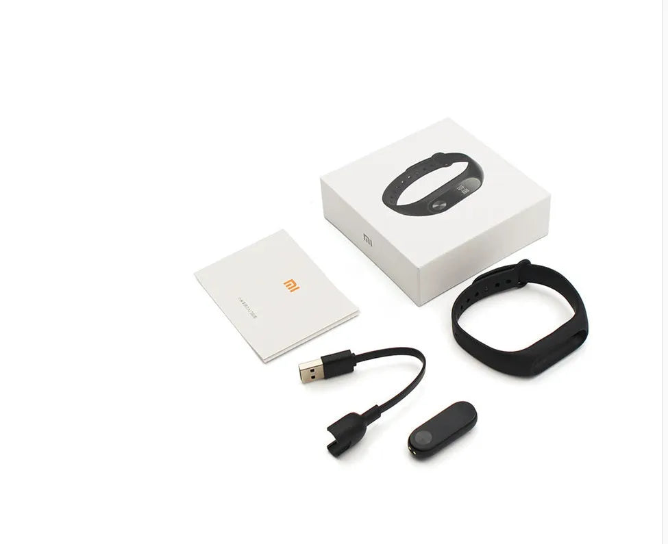 Black Xiaomi Mi Band 2 fitness tracker on wrist showing OLED display with heart rate reading
