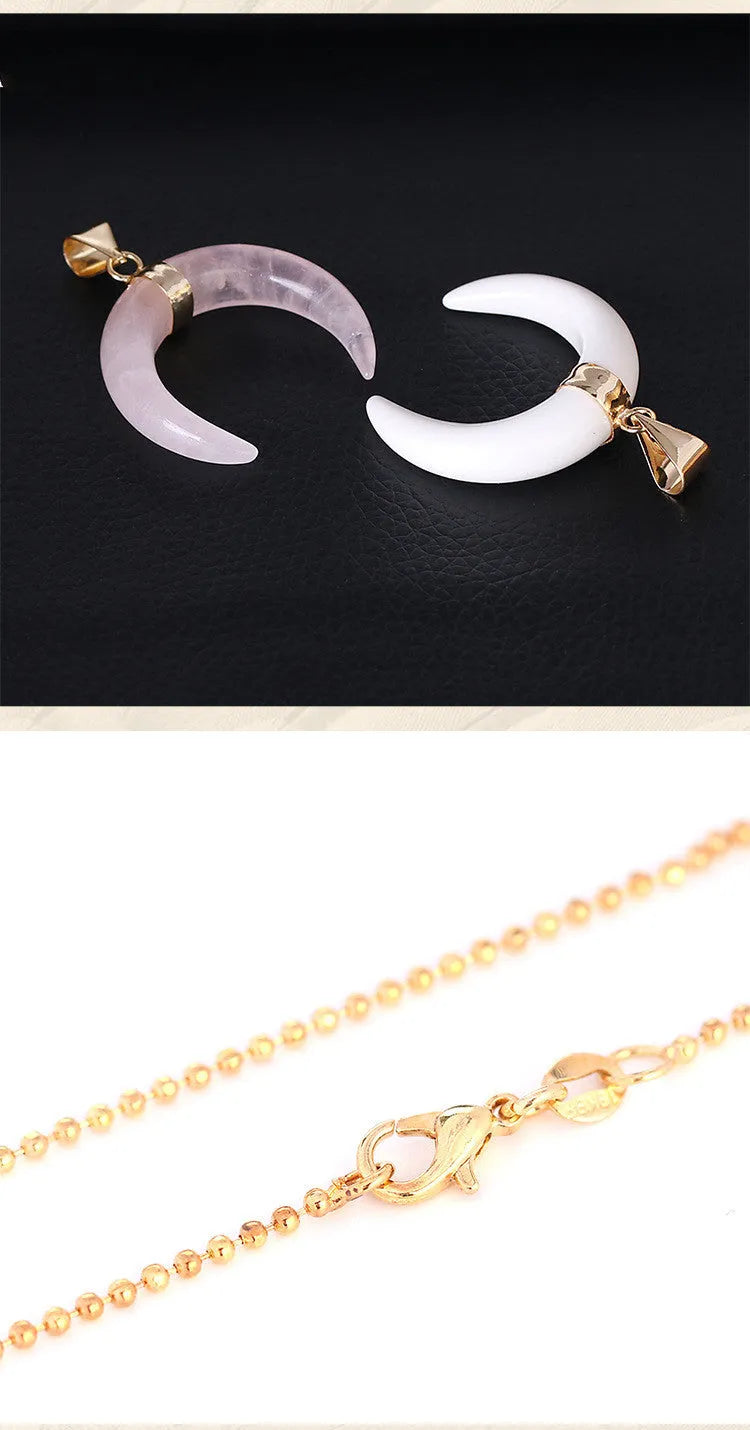 Close-up of a moon pendant necklace with a pink natural stone, on a copper-coloured chain against a neutral background.