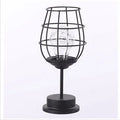 Minimalist hollow iron table lamp in wine glass or bottle design with warm white LED light