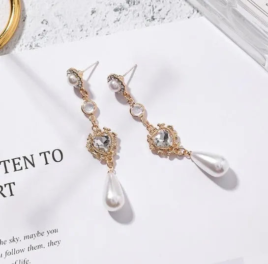 Gold pearl drop earrings with heart-shaped alloy frame and single pearl pendant on gold-tone finish