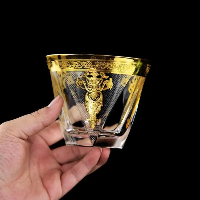 Gold line crystal glass whisky tumbler set with wine bottle and six glasses on a table