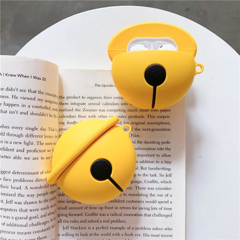 Yellow silicone AirPods case with decorative bell charm for wireless earbuds protection