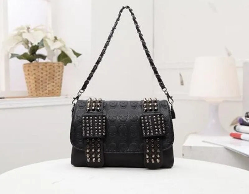 Black leather messenger bag with skull rivets and buckle closure for women