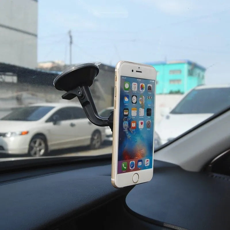 Classic black magnetic car phone holder on dashboard with phone attached, 360-degree rotatable design
