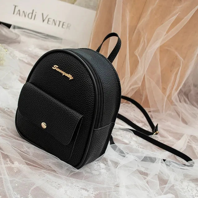 Women's compact black PU bag worn as both a shoulder bag and a small backpack.
