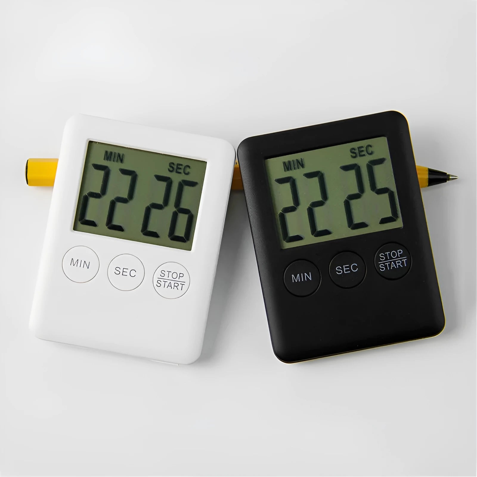 Black and white magnetic kitchen timer with countdown and count-up display on a refrigerator.