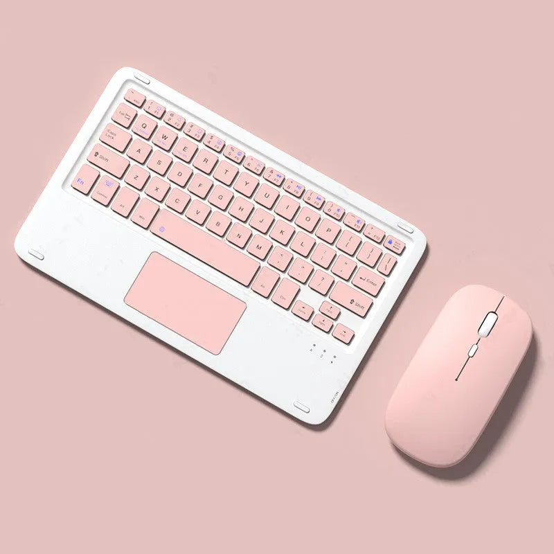 Pink Bluetooth touch keyboard and rechargeable wireless mouse on a desk next to a tablet.