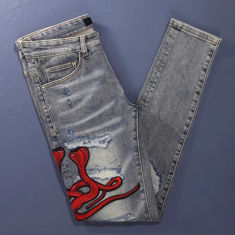 Distressed slim fit jeans with embroidered hole patches in washed-out old colour