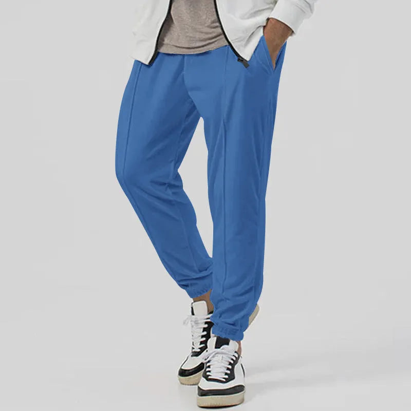 Man wearing gray straight-leg casual track sweatpants with a tapered fit and elastic waistband.