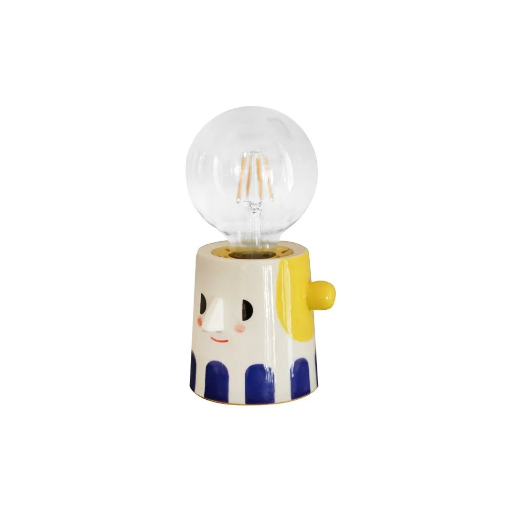 Handmade ceramic table lamp with ball headlight design on a bedside table