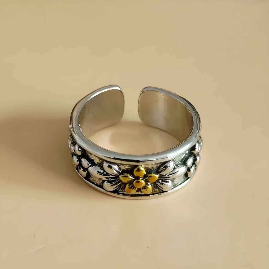 Vintage antique silver gold flower open ring with camellia floral design on a neutral background