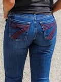 Women's slim fit elastic mid-waist jeans with slight flare and embroidery detail