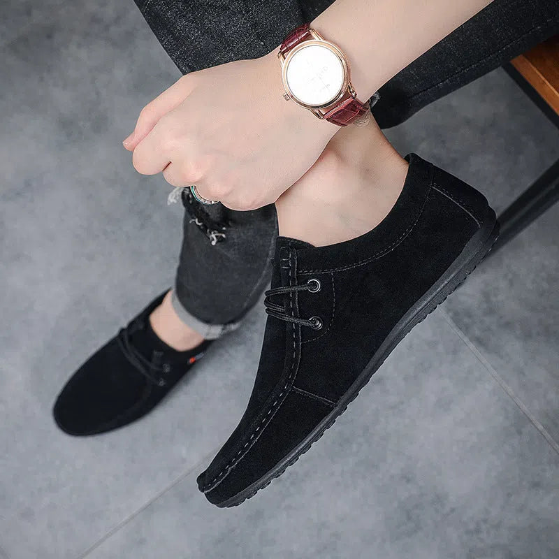 Men's black slip-on loafers with synthetic PU upper, stitched detailing, and non-slip plastic sole