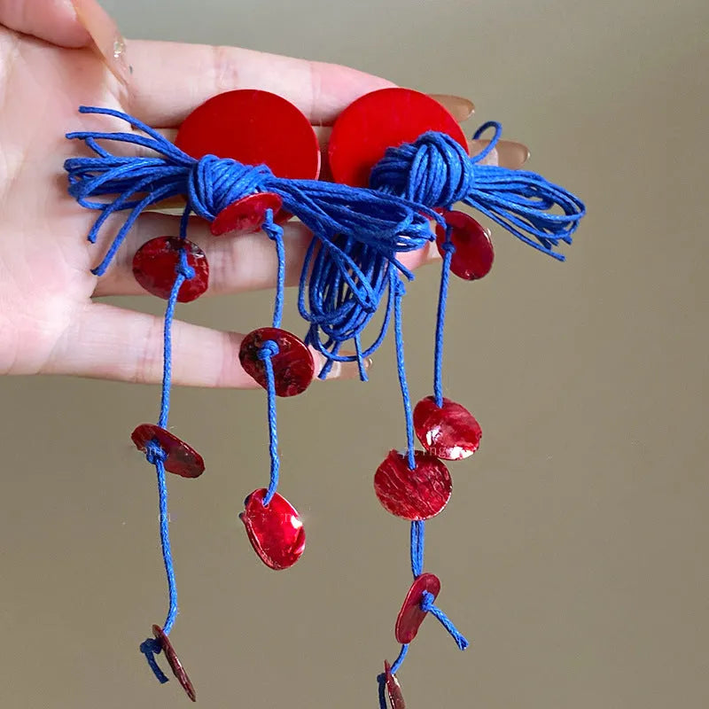 Geometric cloth earrings with blue resin flower detail and round design elements