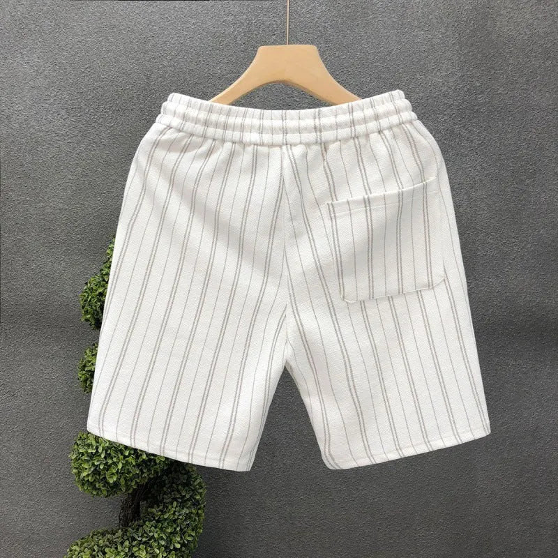 Men's black and white striped fleece-lined casual shorts with an elastic waistband on a grey background.