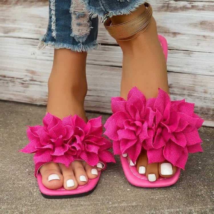 Flat flip-flops with flower decoration in faux leather and rubber sole in black colour for women