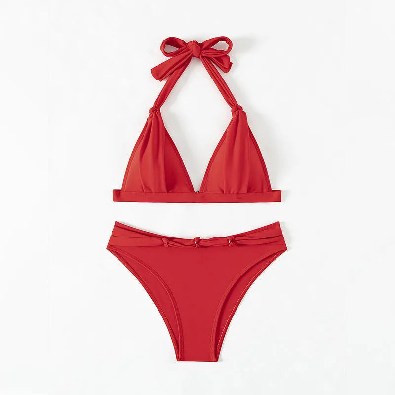 Red women's lace-up halterneck bikini set with matching shorts on mannequin