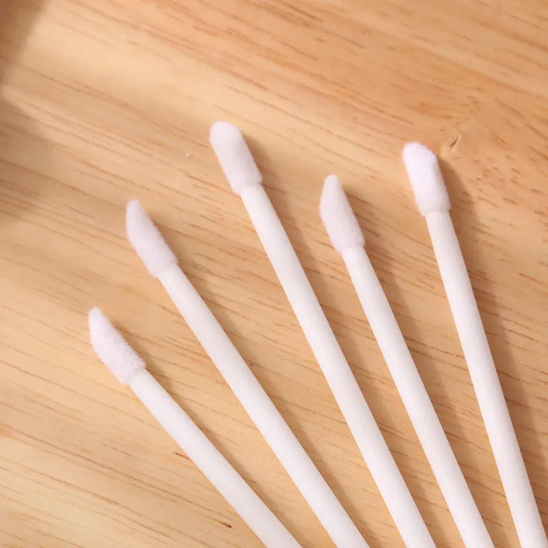 Pack of disposable lip brush applicators with coloured handles and flocked brush tips on a white background