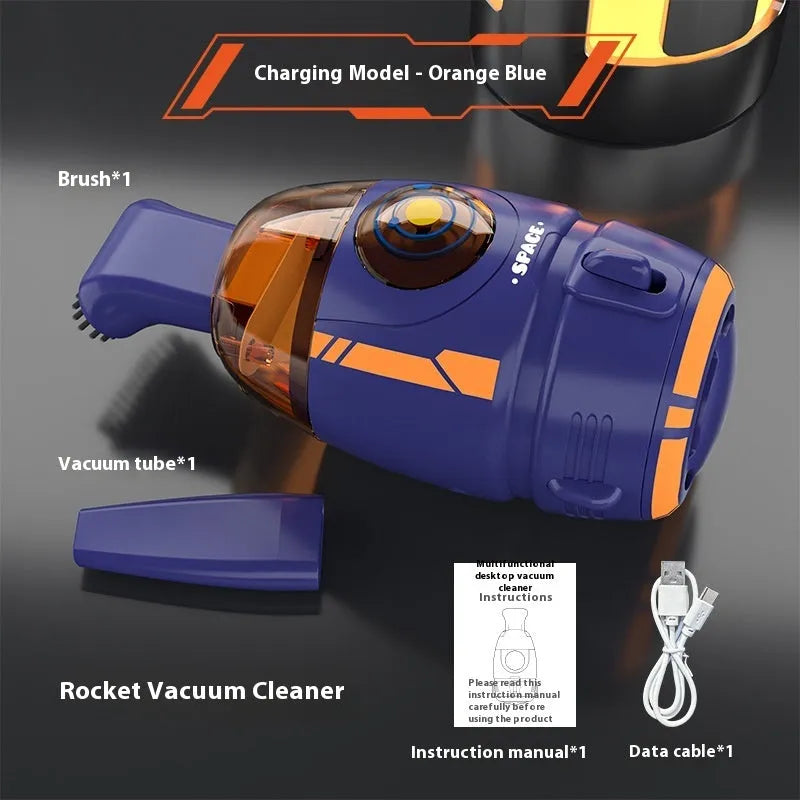 Handheld desktop vacuum cleaner in blue rocket design with USB charging cable on a wooden desk.