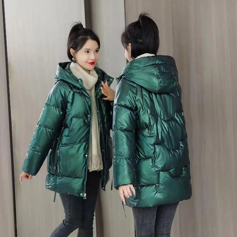 Woman wearing a loose-fit green hooded winter jacket with long sleeves.