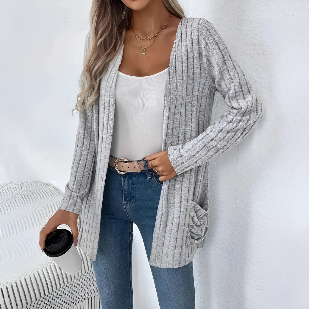 Plus size woman wearing a long sleeve grey cardigan with front pockets, loose fit.