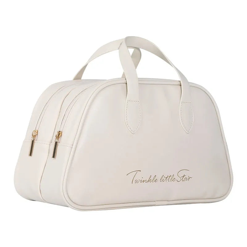 Large leather travel toiletry bag open to show dry and wet separation compartments.