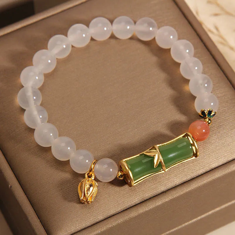 Women's white agate and jade bamboo joint beaded bracelet on a wrist.