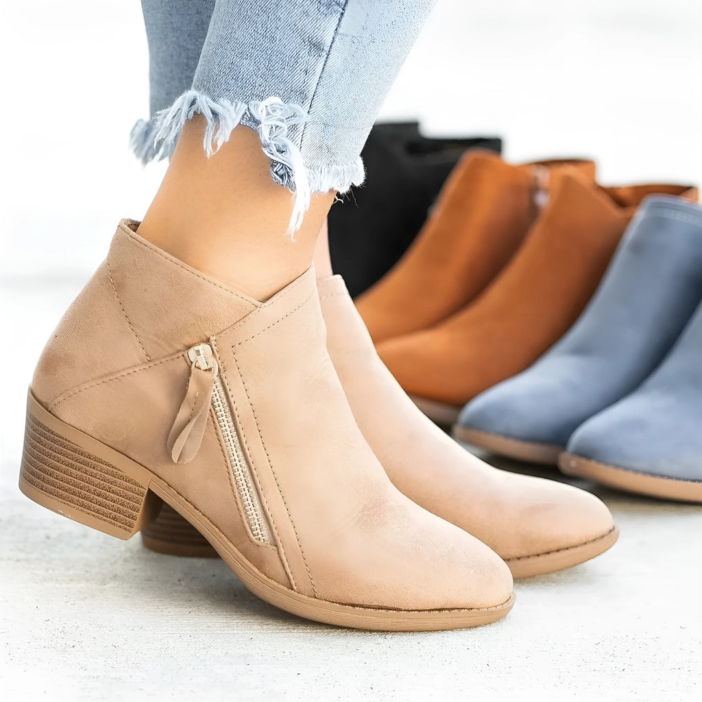 Women's blue suede Dr Martens ankle boots with side zip and chunky heel on a white background.