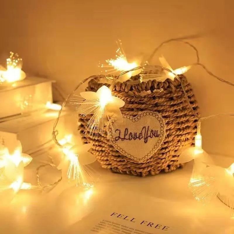 LED optical fibre flower light string with battery box, 20 warm white beads on a dark background