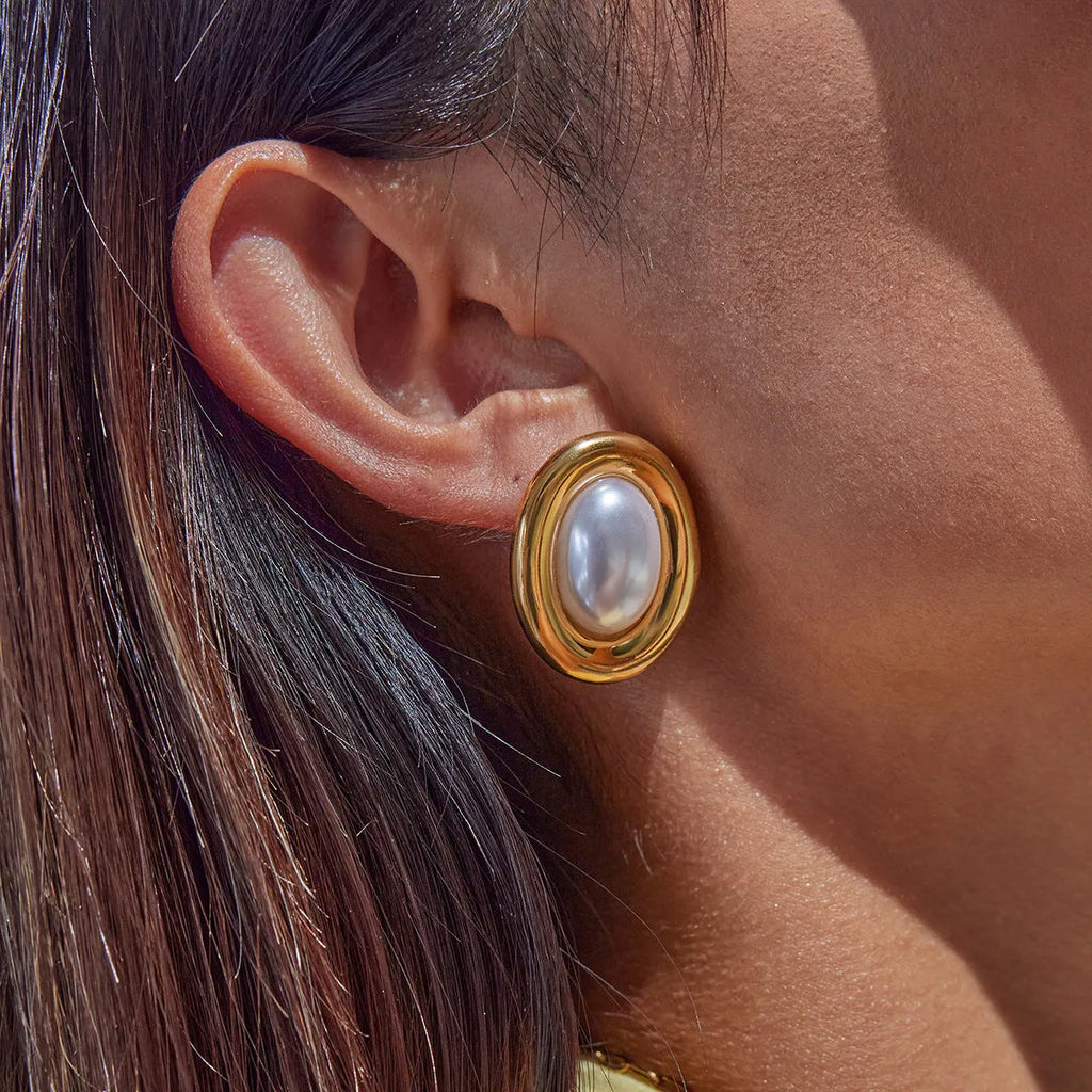 Close-up of women's stainless steel vintage pearl stud earrings with a silver-toned electroplated finish.