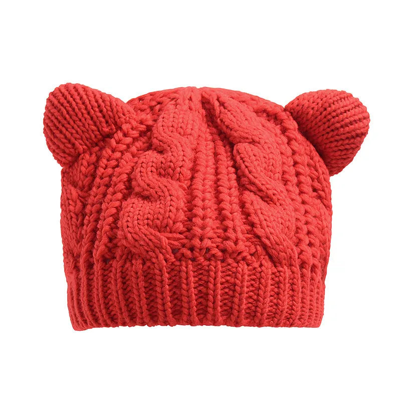 Hand made 3D knitted cat ear beanie in wool, shown in multiple colour options including red, black and beige.