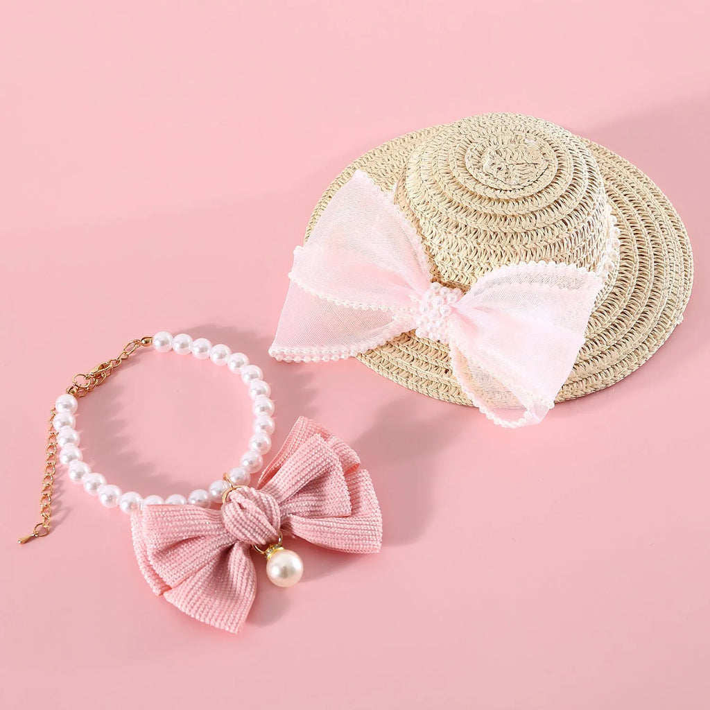 Woven straw hat for a cat with a large central pearl bow, available in blue, pink, purple, and white.