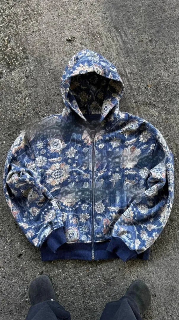 A man's loose-fitting blue hooded zip coat with long sleeves on a hanger.