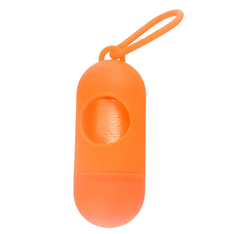 Black plastic dog poop bag holder with a metal side hook and Velcro strap, showing compact size.