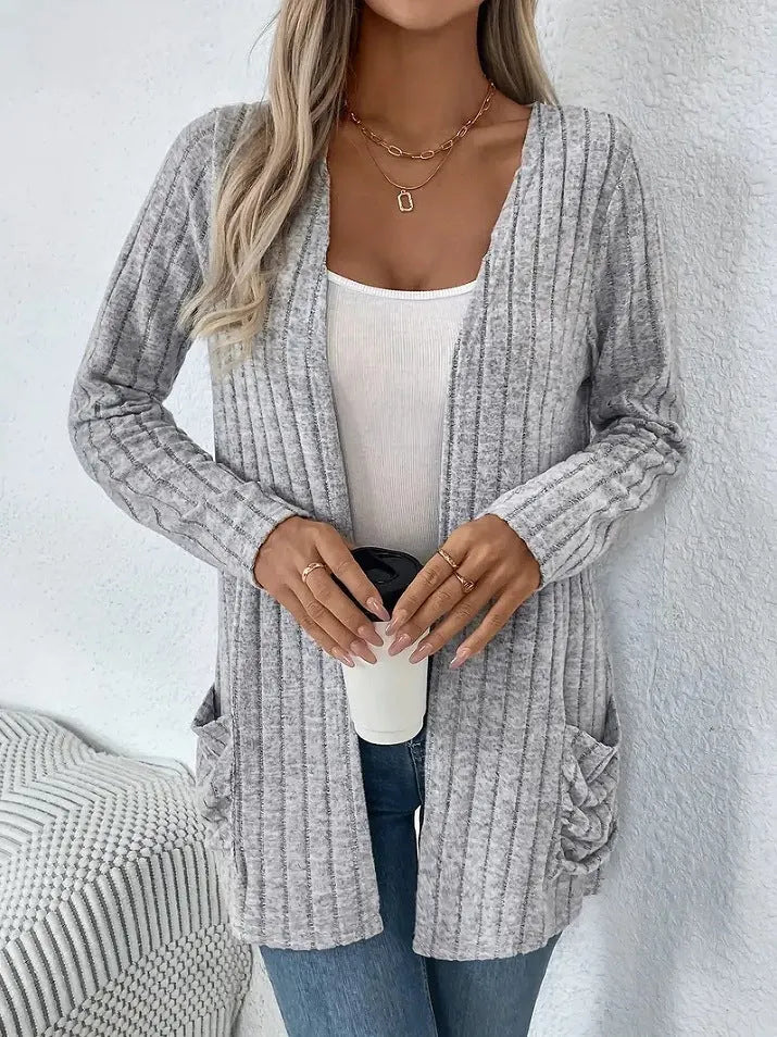 Plus size woman wearing a long sleeve grey cardigan with front pockets, loose fit.