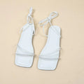 Women's white ankle ring bandage cloth flat sandals with front lace-up and square toe on a rubber sole.