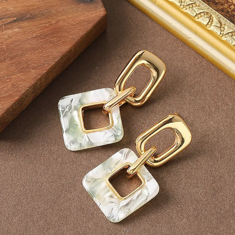 A pair of hollow geometric square earrings with chamfered corners in an electroplated copper finish.