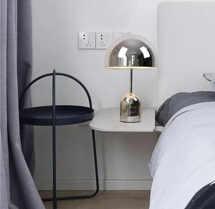 Mushroom-shaped metal table lamp in rose gold finish on wooden surface