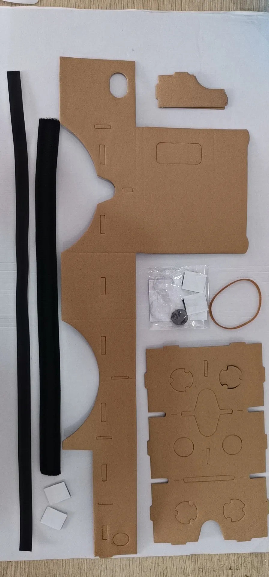 Pink and white cardboard VR glasses for smartphones, shown with 3D lenses and a rubber headband.