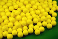 10 yellow PU foam indoor practice golf balls with 41mm diameter on a green surface