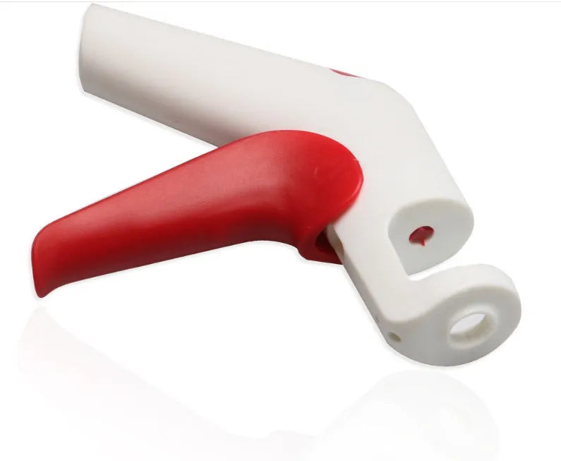 Close-up of a handheld cherry pitter with a plastic handle and stainless steel pitting mechanism
