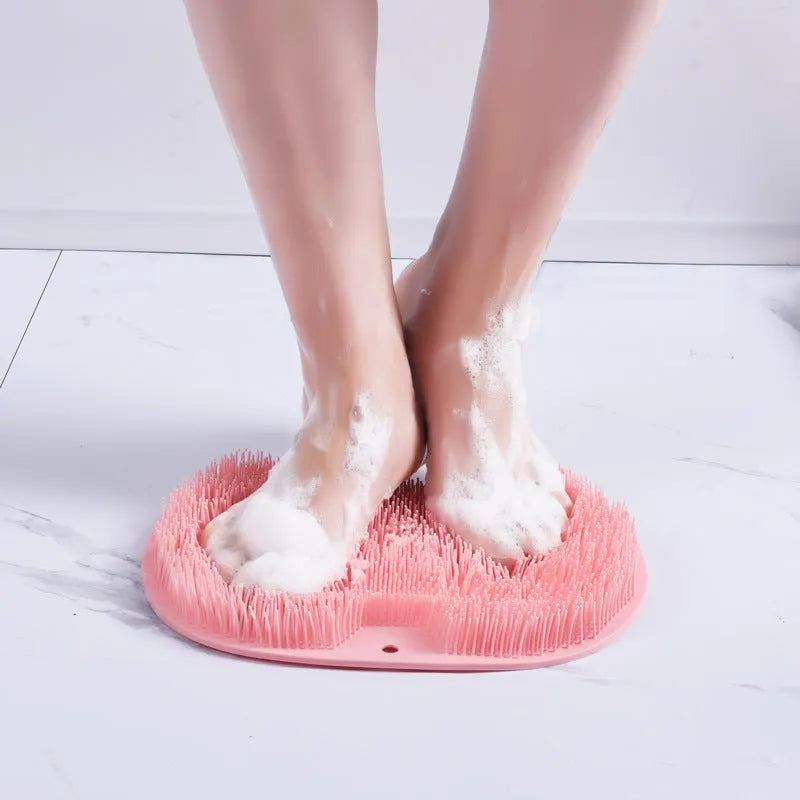 Orange TPR bath brush with silicone bristles and suction cups on base, shown on bathroom tiles.
