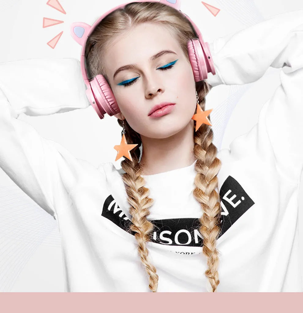Pink and white Luminous Bluetooth wireless over-ear headset with microphone on a table.