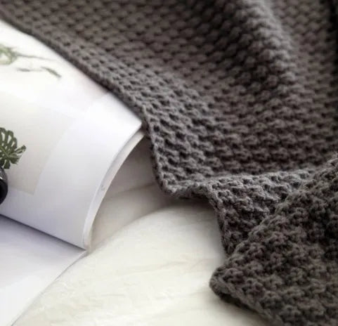 Nordic-style fringed knit acrylic blanket in a neutral colour, laid flat showing its 130x170cm size.